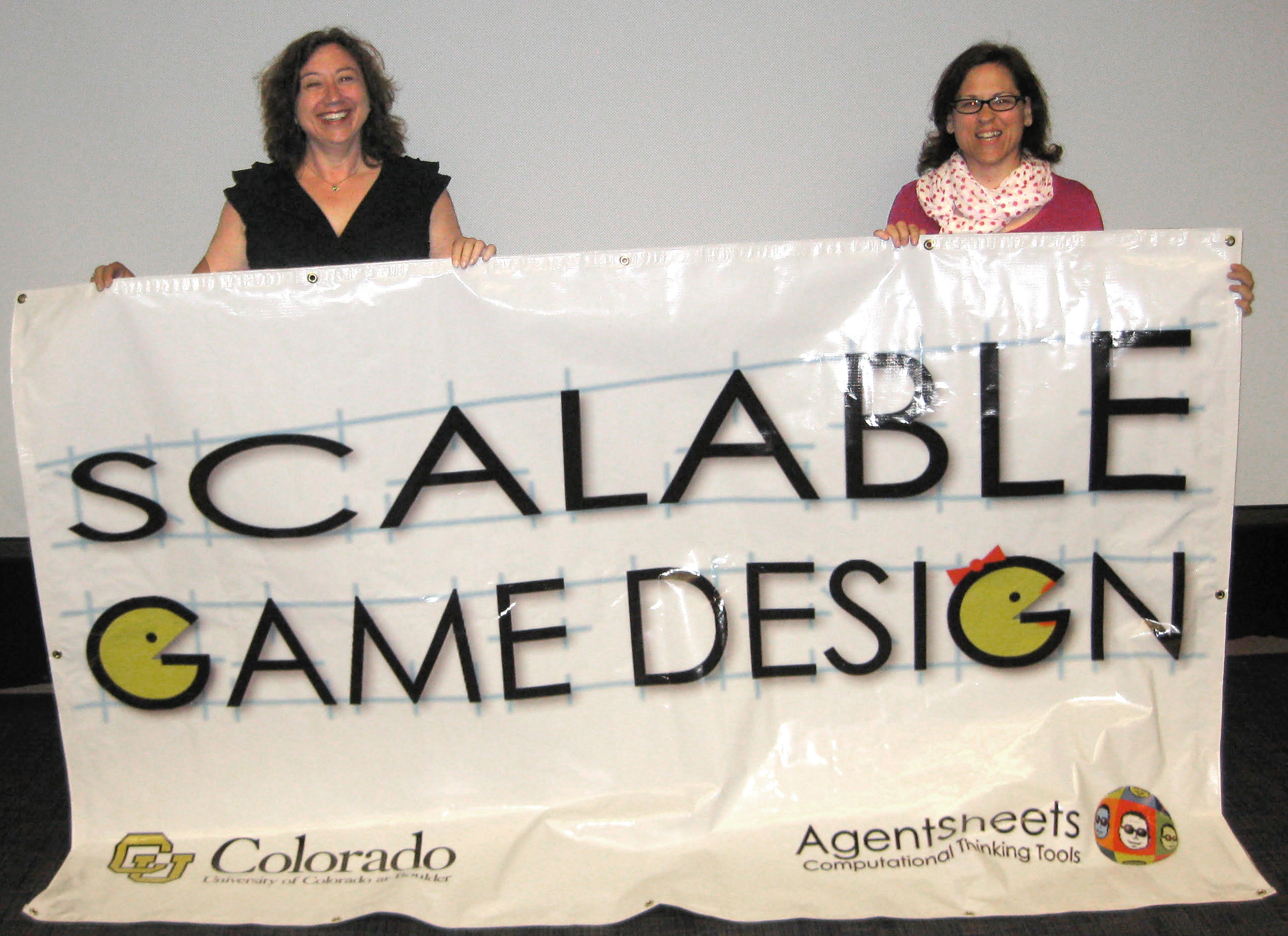 Two founder of Scalable Game Design holding a Scalable Game Design sign.